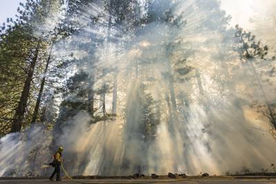Crews battle wildfires across the US West and fight to hold containment lines 