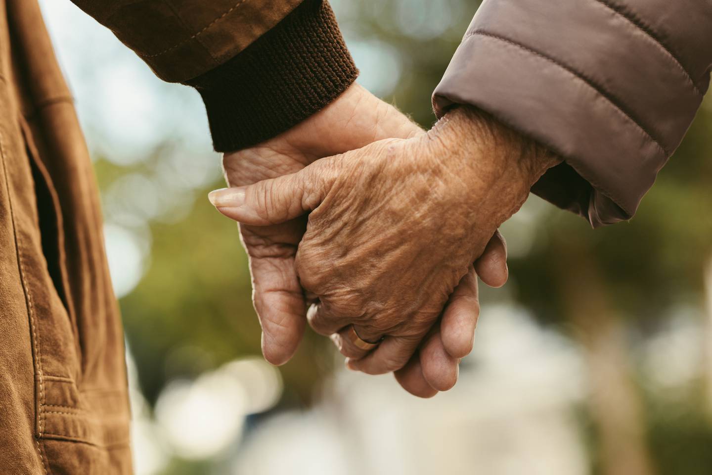 older couple holding hands stock