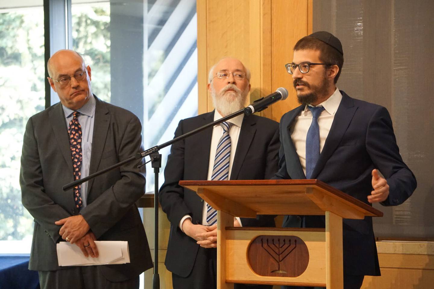 Rabbi Mendy Greenberg, who leads the Chabad congregation in Palmer, speaks at a bill-signing ceremony held Tuesday at the Lubavitch Jewish Center of Alaska. The bill makes vandalism of religous sites a class C felony. Listening is Rep. Andy Josephson, D-Anchorage, who sponsored the bill, and Rabbi Yosef Greenberg, Mendy Greenberg's father, who leads the Anchorage congregation. (Photo by Yereth Rosen/Alaska Beacon)