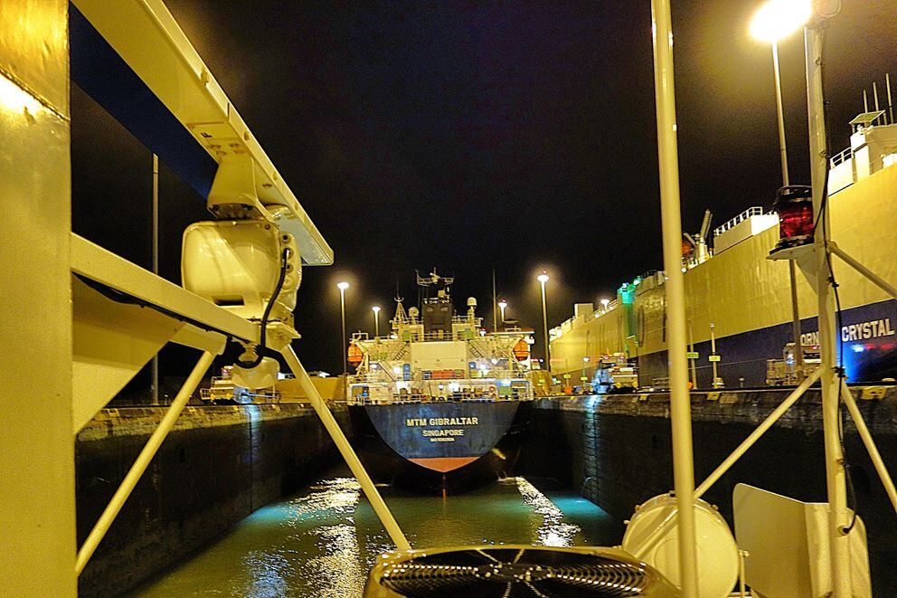 Looking forward from atop the Safari Voyager in the Miraflores Locks near the Port of Balboa on the Pacific side of the Panama Canal. The 462-foot MTM Gibraltar shares the lock for the 88-foot lift up to Lake Gatun. (Notice the electric railroad engines on either side helping to steady the Gibraltar mid-channel.) To the right, the 650-foot car carrier Morning Crystal exits the canal. (Photo by Scott McMurren)