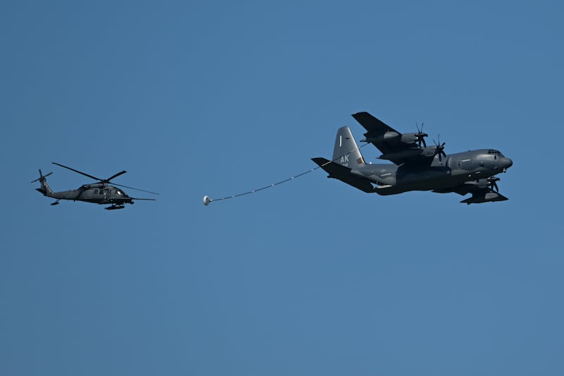 An Alaska Air National Guard HH-60G Pave Hawk helicopter with the 210th Rescue Squadron and a HC-130J Combat King II of the 211th, both from the 176th Wing, demonstrate refueling capabilities on the final day of the Arctic Thunder Open House at Joint Base Elmendorf-Richardson on Sunday, July 21, 2024. (Bill Roth / ADN)