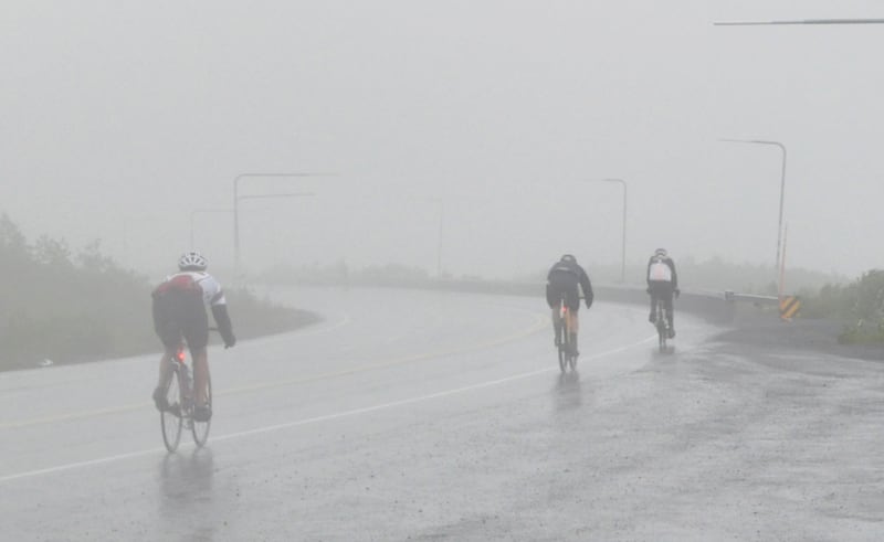 Cyclists begin the steep Richardson Highway descent from Thompson Pass in the wind and rain Saturday, July 13, 2024 during the 200-mile Fireweed bicycle race to Valdez. (Vicky Ho / ADN)