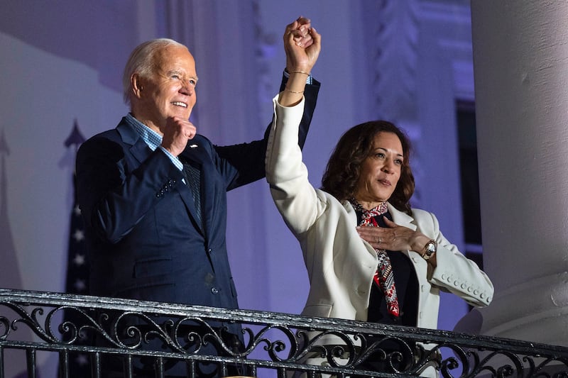 President Joe Biden raises the hand of Vice President Kamala Harris after viewing the Independence Day fireworks display over the National Mall from the balcony of the White House, Thursday, July 4, 2024, in Washington.  (AP Photo/Evan Vucci)