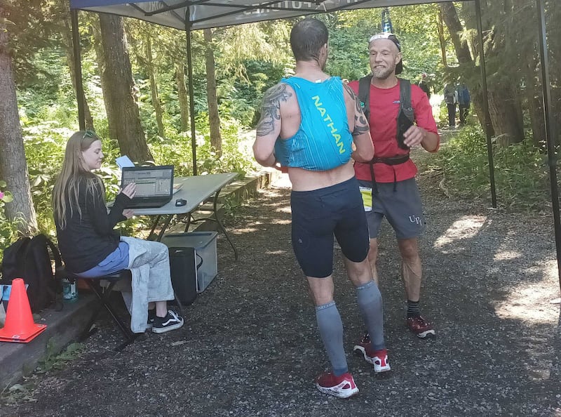 Anchorage's Wesley McQuillin, left, greets second-place finisher Matias Saari at the finish line after coming in first place in the men's division at 39th annual Crow Pass Crossing trail race on Saturday, July 20, 2024 in Eagle River. (Josh Reed / ADN)
