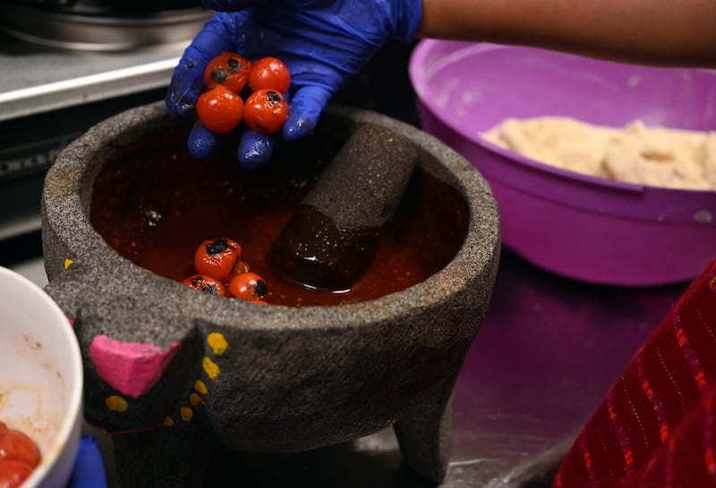 Rosi Martinez Marthel prepares to crush small tomatoes into salsa at Salsa Oaxaquena. (Anne Raup / ADN)
