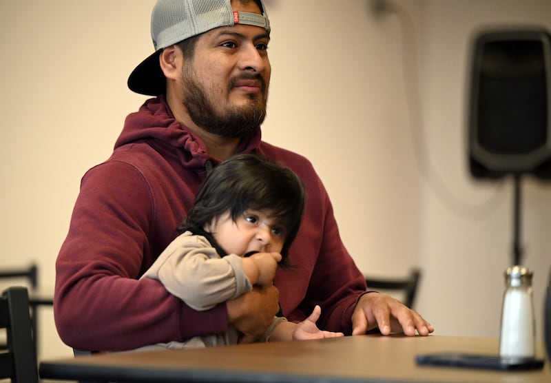 Abraham Martinez Marthel speaks about his restaurant at Salsa Oaxaquena. He holds his 6-month-old son, Ivan Angel Marthel Vazquez.  (Anne Raup / ADN)