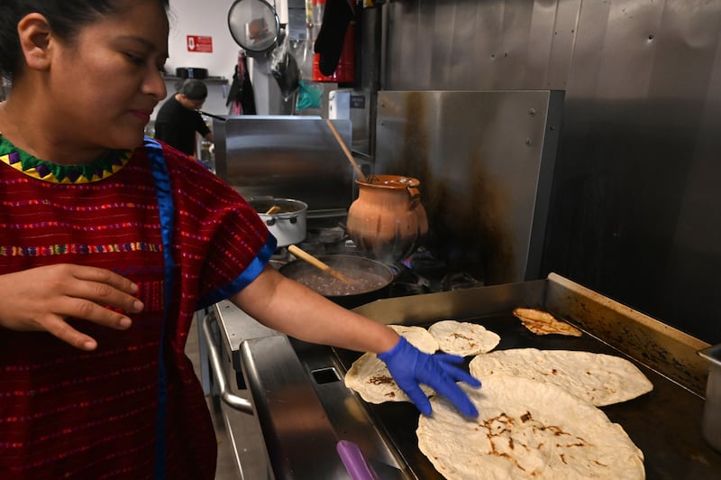 Rosi Martinez Marthel warms tortillas on the grill. (Anne Raup / ADN)