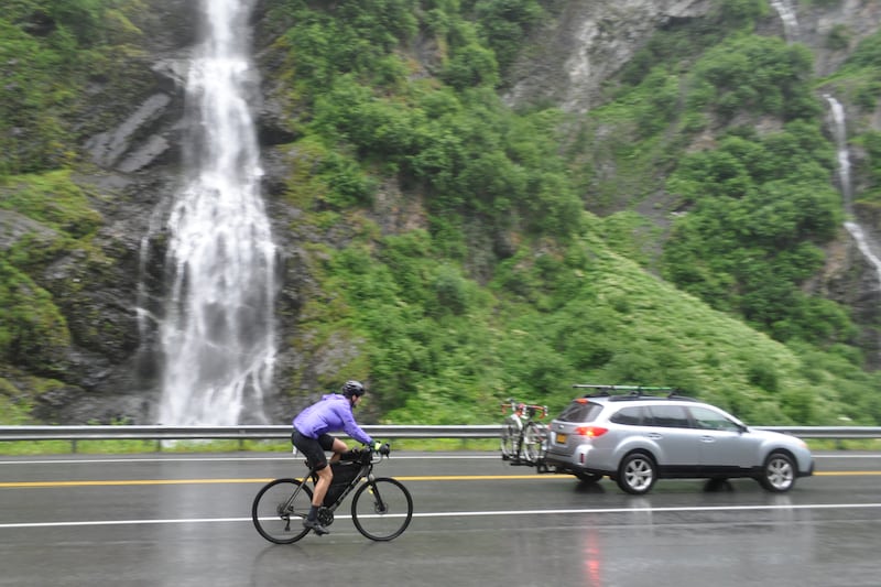 Solo cyclist Joe Cullen rides past Bridalveil Falls in Keystone Canyon during the 200-mile Fireweed race to Valdez on Saturday, July 13, 2024. (Vicky Ho / ADN)