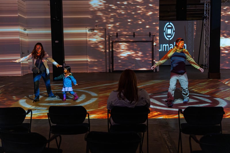 The Caballes family, visiting from Tennessee, tries out the interactive experience at LumaLim in downtown Anchorage. From left: Heather, Evelyn (3), and Ervin. (Loren Holmes / ADN)