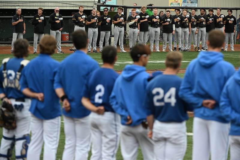 The Anchorage Bucs, top, and Anchorage Glacier Pilots, foreground, during the national anthem at Mulcahy Stadium on Monday, July 10, 2023. (Bill Roth / ADN) 