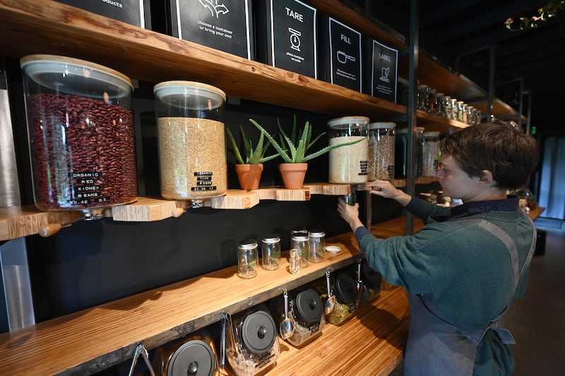 Raw Market co-owner Michelle Young fills a jar with organic royal white quinoa in the recently opened refillery, juice bar and grocer in Girdwood. (Bill Roth / ADN)