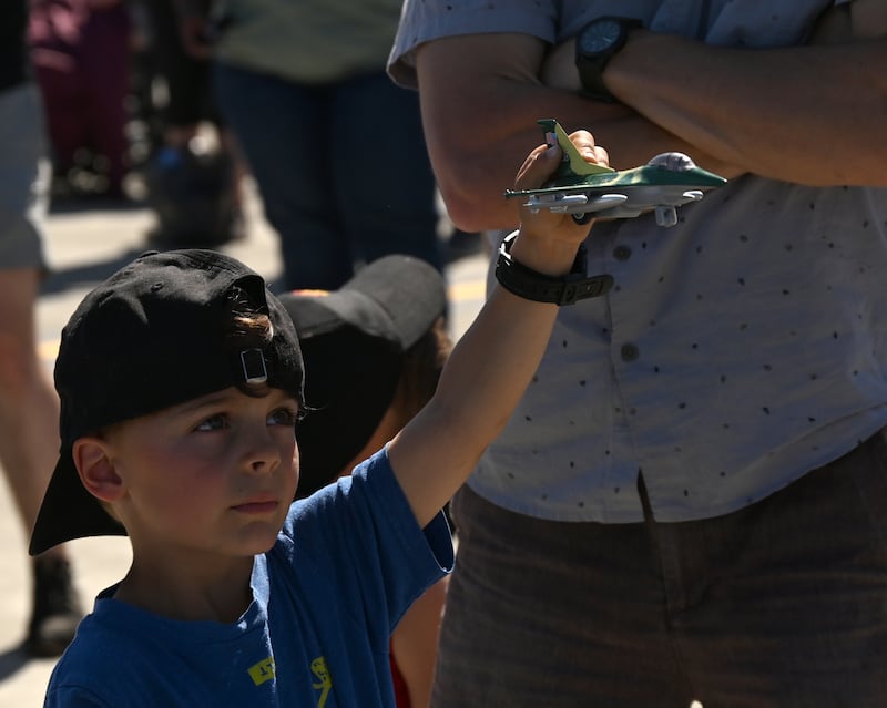 Hugo Thomas holds up his F-16 model as he and his dad and brother watch the F-16 demonstration during the Arctic Thunder air show. (Bob Hallinen Photo)

