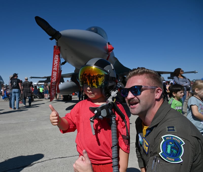 6-year-old Ethan Dolchok, from Anchorage, wears the helmet of F-16C pilot Captain Aaron "Pulse" Tollon as he poses for the photo with Tollon during the Arctic Thunder Open House. Tollon's 18th Fighter Intercepter Squadron is stationed at Eielson Air Force Base outside of Fairbanks. (Bob Hallinen Photo)

