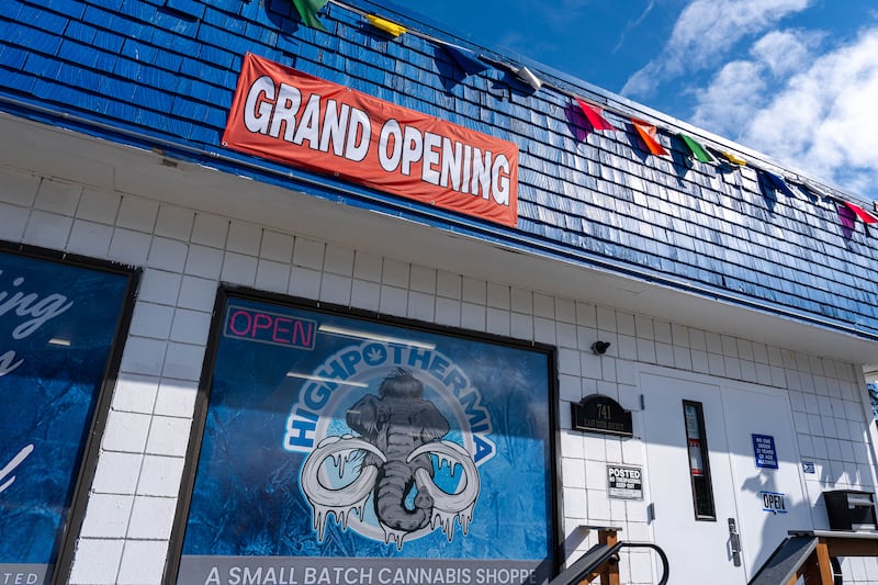 A grand opening sign hangs from the side of Highpothermia, a new retail cannabis shop in Fairview. (Loren Holmes / ADN)