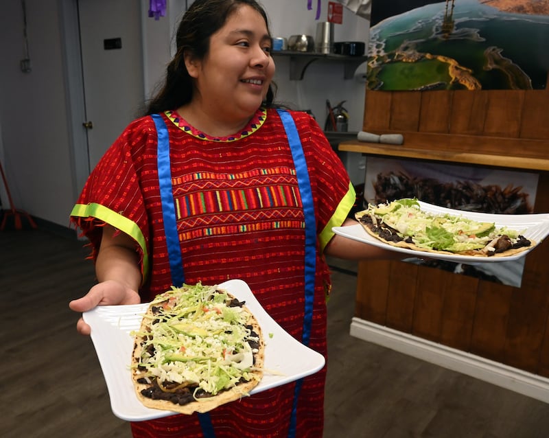 Selena Vazquez Lopez holds plates of huarache at Salsa Oaxaquena. (Anne Raup / ADN)
