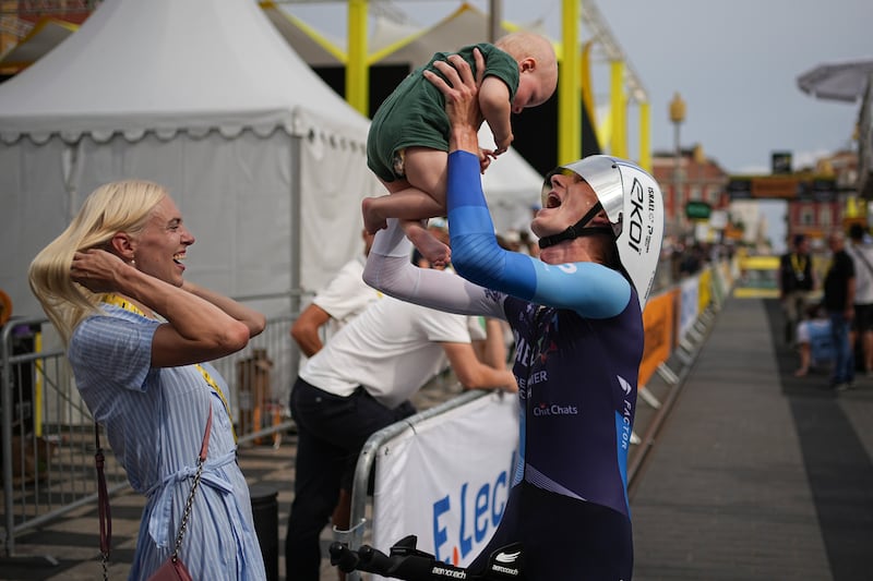 Latvia's Krists Neilands celebrates with his family after crossing the finish line of the twenty-first stage of the Tour de France cycling race, an individual time trial over 33.7 kilometers (20.9 miles) with start in Monaco and finish in Nice, France, Sunday, July 21, 2024. (AP Photo/Laurent Cipriani, Pool)