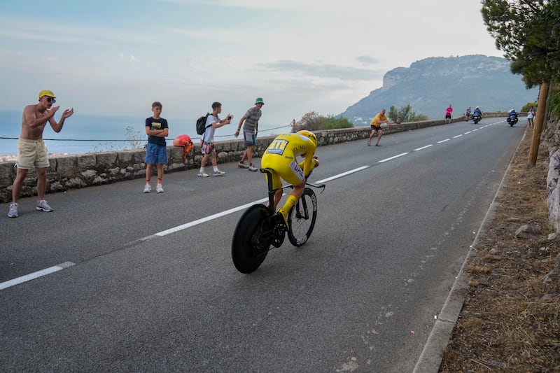 Slovenia's Tadej Pogacar, wearing the overall leader's yellow jersey, climbs during the twenty-first stage of the Tour de France cycling race, an individual time trial over 33.7 kilometers (20.9 miles) with start in Monaco and finish in Nice, France, Sunday, July 21, 2024. (AP Photo/Jerome Delay)