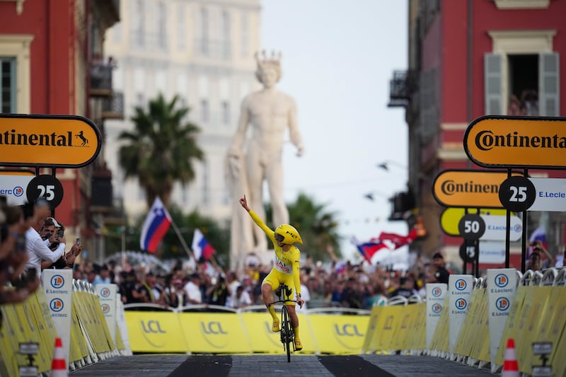 Tour de France winner Slovenia's Tadej Pogacar, wearing the overall leader's yellow jersey, celebrates as he crosses the finish line of the twenty-first stage of the Tour de France cycling race, an individual time trial over 33.7 kilometers (20.9 miles) with start in Monaco and finish in Nice, France, Sunday, July 21, 2024. (AP Photo/Daniel Cole)