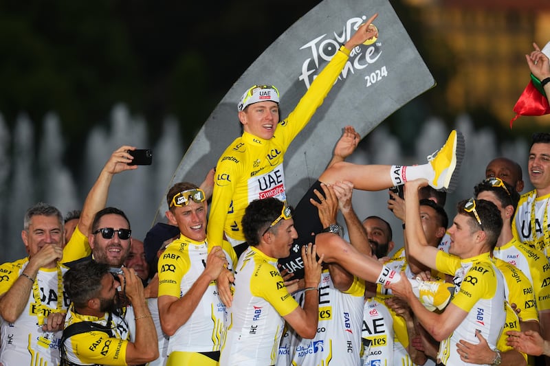 Tour de France winner Slovenia's Tadej Pogacar celebrates with his team after the twenty-first stage of the Tour de France cycling race, an individual time trial over 33.7 kilometers (20.9 miles) with start in Monaco and finish in Nice, France, Sunday, July 21, 2024. (AP Photo/Daniel Cole)